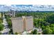 High-rise condo building with pool and parking garage surrounded by lush greenery with city skyline views at 2479 Peachtree Ne Rd # 1801, Atlanta, GA 30305