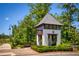 Aria community entrance featuring a charming guardhouse with brick accents and a manicured landscape at 6790 Encore Blvd, Sandy Springs, GA 30328