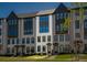 New construction townhomes with light brick, black accents, and green grass at 6790 Encore Blvd, Sandy Springs, GA 30328