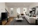 Living room with a large sectional couch, modern decor, and lots of natural light at 6790 Encore Blvd, Sandy Springs, GA 30328