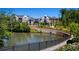 Scenic pond view with elegant residential buildings, complemented by stone bridge and lush landscaping, a tranquil community setting at 6790 Encore Blvd, Sandy Springs, GA 30328