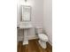 Elegant powder room featuring pedestal sink, modern fixtures, and wood flooring. Toilet shown at 6790 Encore Blvd, Sandy Springs, GA 30328
