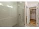Modern bathroom featuring a glass shower with gray tile and a glimpse into a walk-in closet at 6790 Encore Blvd, Sandy Springs, GA 30328