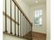 Staircase with black metal balusters and wood handrail leads to upper level, bathed in natural light at 6790 Encore Blvd, Sandy Springs, GA 30328