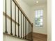 Staircase with a dark metal railing and hardwood steps, alongside a window providing natural light at 6790 Encore Blvd, Sandy Springs, GA 30328
