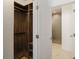 A custom walk-in closet with wooden organizers and a glimpse of a modern bathroom with a tiled shower at 6790 Encore Blvd, Sandy Springs, GA 30328