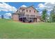 A sprawling green backyard featuring a multi-level deck and patio, ideal for outdoor enjoyment at 859 Heritage Lake Way, Grayson, GA 30017
