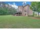 Home exterior features a large yard, a wooden deck, a covered patio, and mature trees at 859 Heritage Lake Way, Grayson, GA 30017