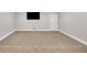 Spacious carpeted basement with ample room for activities, featuring a mounted television and white trim at 859 Heritage Lake Way, Grayson, GA 30017