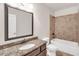 Bathroom featuring granite counters, dark wood cabinets, and a tiled shower and tub combo with bronze fixtures at 859 Heritage Lake Way, Grayson, GA 30017