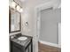 Bathroom with dark vanity, granite countertops, and a framed mirror above the sink at 859 Heritage Lake Way, Grayson, GA 30017