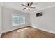 Bedroom with ceiling fan, hardwood floors, and a large window offering natural light at 859 Heritage Lake Way, Grayson, GA 30017