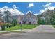Charming two-story house with brick and stone, lush landscaping, long driveway, and a sunny sky at 859 Heritage Lake Way, Grayson, GA 30017