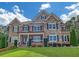 Elegant two-story home with a combination brick and stone facade, manicured lawn, and mature landscaping at 859 Heritage Lake Way, Grayson, GA 30017