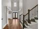 Grand foyer with gleaming hardwood floors, soaring ceilings, staircase, and leaded glass entry doors at 859 Heritage Lake Way, Grayson, GA 30017