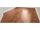 Close up of shining, light-brown hardwood flooring with white baseboards along the walls at 859 Heritage Lake Way, Grayson, GA 30017