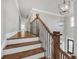 Staircase with hardwood steps, an iron railing, and a modern light fixture above the foyer at 859 Heritage Lake Way, Grayson, GA 30017