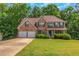 Charming brick home featuring a two-car garage and a well-manicured front lawn at 11354 Conner Ct, Hampton, GA 30228
