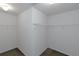 Walk-in closet features with white shelving, neutral walls, and concrete flooring at 11354 Conner Ct, Hampton, GA 30228