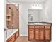 Well-lit bathroom featuring a bathtub with shower, vanity, and tiled walls at 1508 Franklin Cir, Dacula, GA 30019