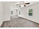 Large bedroom with neutral carpet, multiple windows, and two ceiling fans at 1508 Franklin Cir, Dacula, GA 30019