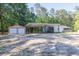 Exterior view showcasing a gravel driveway, carport, home and separate garage at 1508 Franklin Cir, Dacula, GA 30019