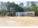 Attractive single-story home with a long porch, carport, and two-car garage, nestled in a wooded setting at 1508 Franklin Cir, Dacula, GA 30019