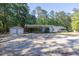 Exterior view showcases the home, carport, and detached garage, surrounded by mature trees at 1508 Franklin Cir, Dacula, GA 30019
