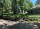 Scenic view of home's landscape with a stone wall and steps leading to the front, surrounded by mature trees at 181 Eureka Ne Dr, Atlanta, GA 30305