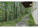 Lush backyard featuring rock steps, wooded views, and exterior of home; virtually staged for inspiration at 5034 Hickory Hills Dr, Woodstock, GA 30188