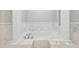 Luxurious soaking tub with marble surround and classic fixtures at 5034 Hickory Hills Dr, Woodstock, GA 30188