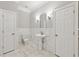 Elegant powder room with white marble accents, pedestal sink, and tiled floors at 5034 Hickory Hills Dr, Woodstock, GA 30188