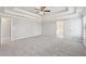 Open bedroom features a tray ceiling, neutral carpet, and an ensuite bath at 5034 Hickory Hills Dr, Woodstock, GA 30188