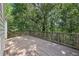 Spacious outdoor deck with decorative railing offers a tranquil setting surrounded by mature trees at 5034 Hickory Hills Dr, Woodstock, GA 30188