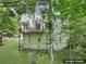 Rear exterior view of home showcasing deck, serene backyard, mature trees, and lush landscaping at 5034 Hickory Hills Dr, Woodstock, GA 30188
