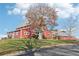 Stunning red barn-style community building on a lush green lawn with mature trees, set against a blue sky at 5034 Hickory Hills Dr, Woodstock, GA 30188