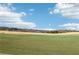 Expansive golf course with manicured green fairways set against a backdrop of trees and a clear blue sky at 5034 Hickory Hills Dr, Woodstock, GA 30188