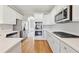 Modern kitchen boasts stainless steel appliances, white cabinets, and quartz countertops at 5034 Hickory Hills Dr, Woodstock, GA 30188