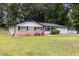 Charming single-story home with a well-manicured lawn, brick facade, and attached garage, offering great curb appeal at 1753 Pounds Rd, Stone Mountain, GA 30087
