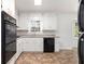 Bright kitchen showcasing white cabinets, a window view, and black appliances at 1753 Pounds Rd, Stone Mountain, GA 30087