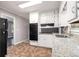 Well-lit kitchen featuring white cabinetry, black appliances, and granite countertops at 1753 Pounds Rd, Stone Mountain, GA 30087
