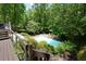 Backyard view of an in-ground pool from the deck with lush landscaping at 1760 Little Willeo Rd, Marietta, GA 30068