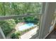 View of backyard pool surrounded by lush trees from window in bedroom at 1760 Little Willeo Rd, Marietta, GA 30068