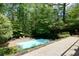 Backyard oasis featuring an in-ground pool surrounded by lush, mature trees at 1760 Little Willeo Rd, Marietta, GA 30068