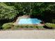 Aerial view of a sparkling in-ground pool surrounded by lush landscaping and mature trees at 1760 Little Willeo Rd, Marietta, GA 30068