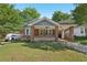 Charming brick home with a covered front porch and a well-maintained lawn at 1841 Thompson Ave, Atlanta, GA 30344