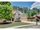 Charming two-story brick home with a well-manicured lawn, mature trees, and a two-car garage at 204 Arthur Hills Dr, Acworth, GA 30101