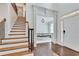 Bright foyer with hardwood floors, a staircase with wooden treads, and an open view to the dining room at 204 Arthur Hills Dr, Acworth, GA 30101