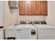 Functional laundry room with white washer, dryer, utility sink, and ample storage cabinets at 204 Arthur Hills Dr, Acworth, GA 30101