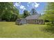 View of the backyard with an outbuilding and large green lawn at 2416 Hurt Sw Rd, Marietta, GA 30008